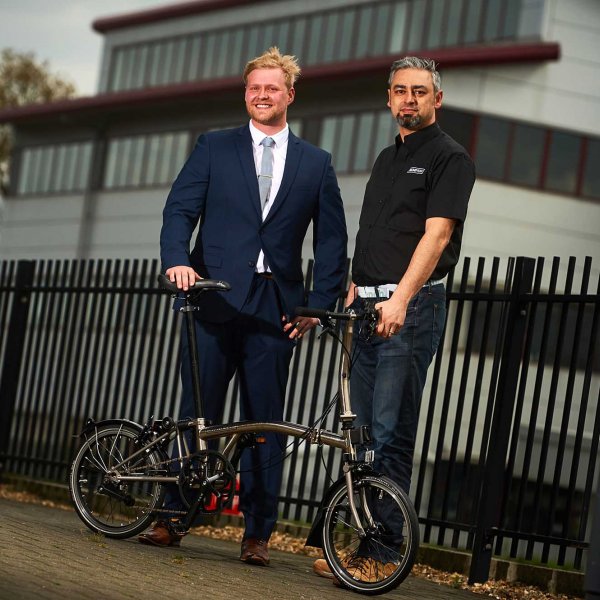 brompton_sj_24  © Licensed to simonjacobs.com. 18.04.16 Greenford, UK.Gareth Ridge, Surface technology Business Development Executive, (blue suit) and Brompton Design Operations Manager Mo Rahnama with the Surface Technology special edition Nickel Brompton Bike.FREE PRESS, EDITORIAL AND PR USAGE.Photo credit: Simon Jacobs